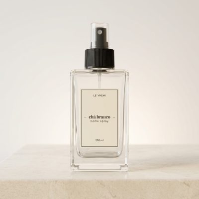 Foto frontal e nítida do frasco de vidro do Home Spray Chá Branco 200ml Le' Vhemi. O frasco é transparente, mostrando o líquido no interior, com um rótulo minimalista e elegante. Ele está centralizado e focado, transmitindo sofisticação e leveza.